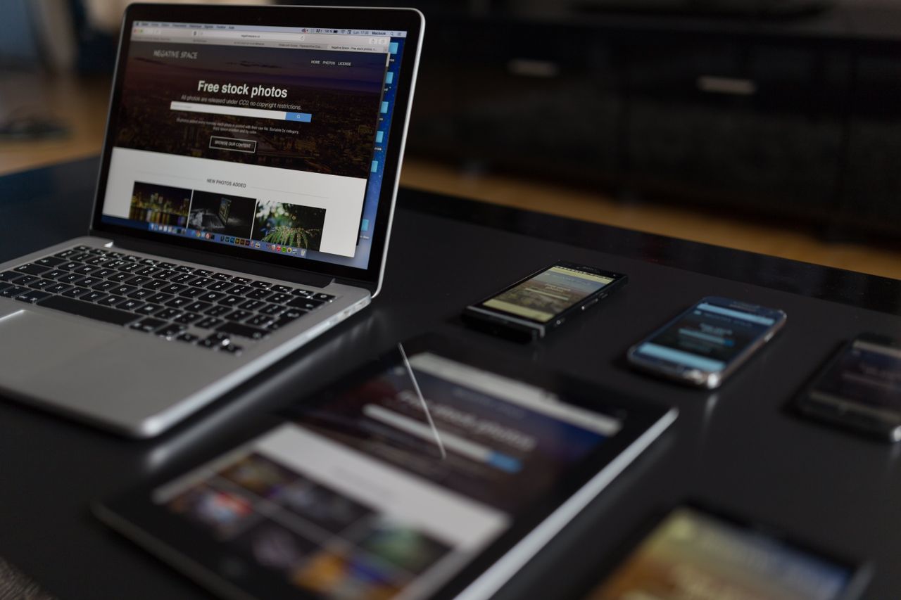 Un espace de travail moderne présentant un ordinateur portable, une tablette et des smartphones, parfait pour un usage tech et freelance.