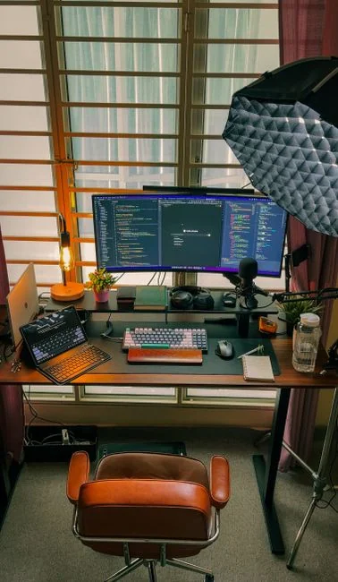 Un espace de travail moderne avec deux écrans d’ordinateur affichant des projets de web design, mettant en avant la technologie et la productivité.